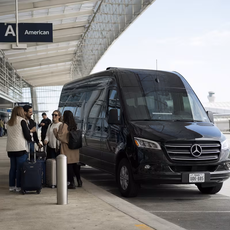 Group boarding a white charter bus for Airport Transportation transportation in Irving