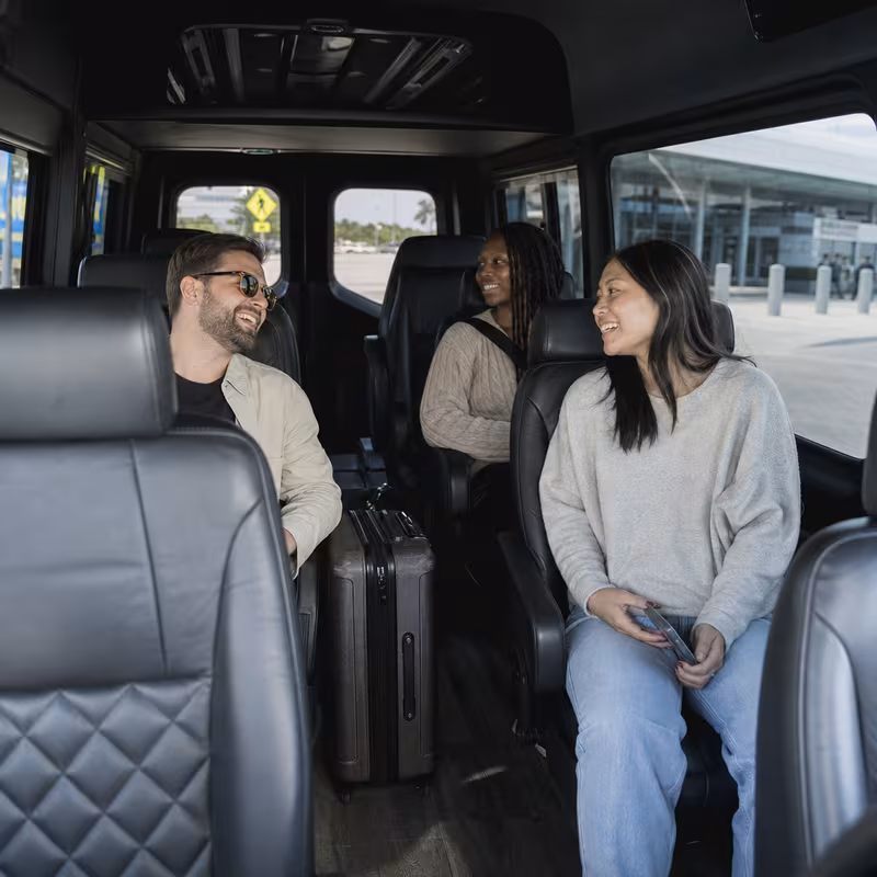 Passengers loading luggage while boarding an Irving group shuttle