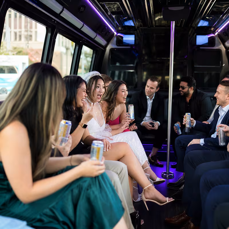 Party bus interior with wraparound leather seating and LED lighting in Irving
