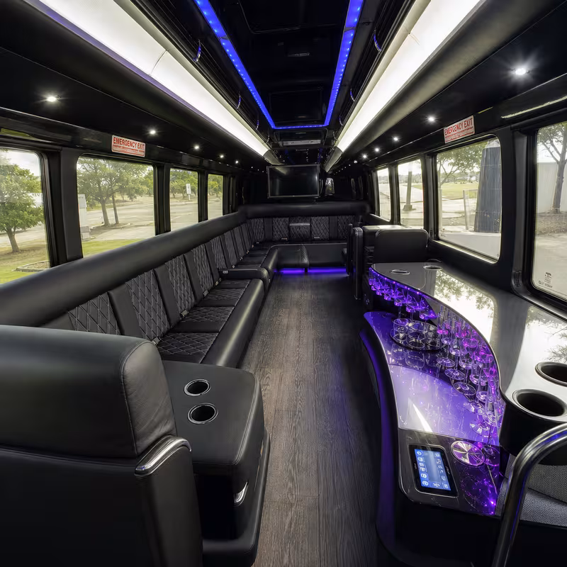 Party bus interior with wraparound leather seating and LED lighting in Irving