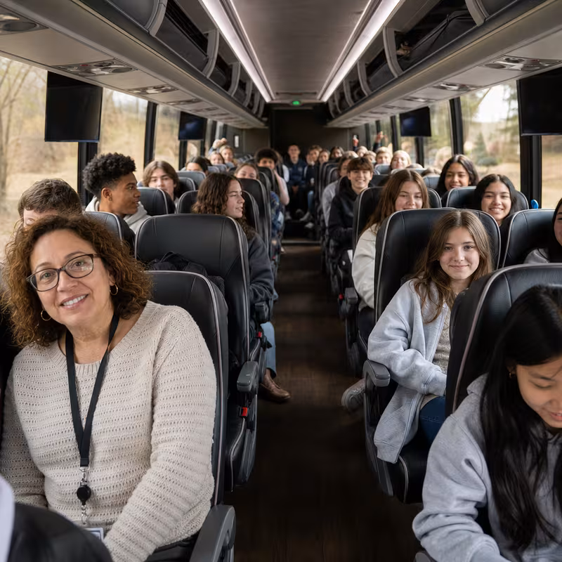 Group boarding a white charter bus for School Transportation transportation in Irving
